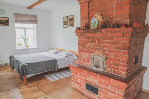 a bedroom with a brick fireplace with a bed at Aimasas in Soleimi