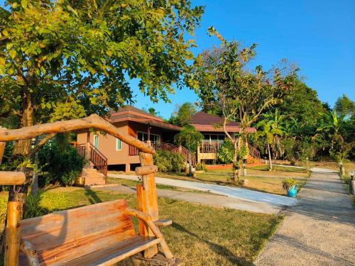 um banco de madeira sentado em frente a uma casa em Sunrise Beach Kohyao Resort em Ko Yao Yai