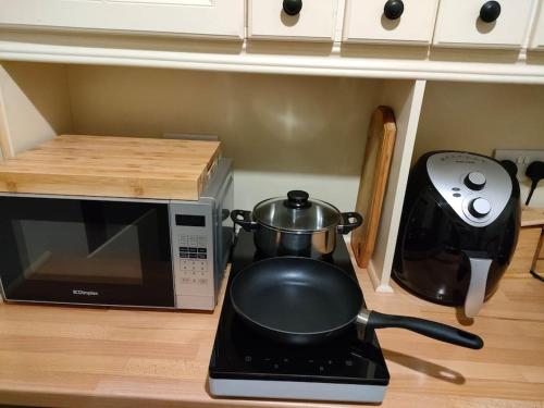 a kitchen counter with a microwave and a tea kettle at Hidden Hearts Apartment in Roscrea