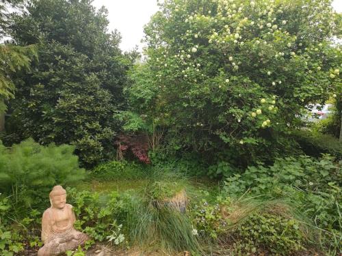 a statue sitting in the middle of a garden at Hidden Hearts Apartment in Roscrea