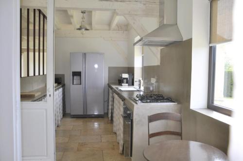 eine Küche mit einem Herd und einem Kühlschrank in der Unterkunft les gîtes de fred en Dordogne, Maisons avec piscines privées et chauffées in Florimont-Gaumiers