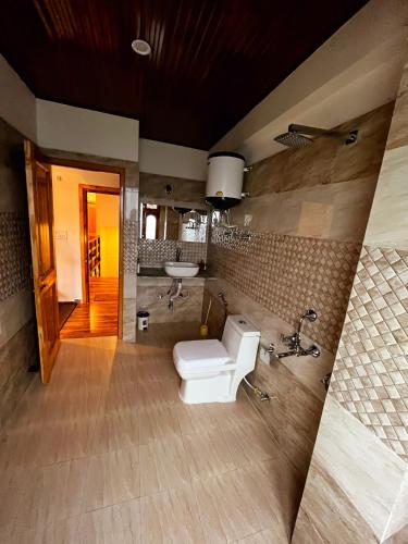 a bathroom with a toilet and a sink in it at THE LANDSBY COTTAGES in Nagar