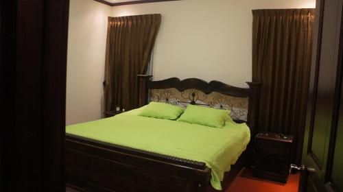 1 dormitorio con 1 cama con edredón verde en Casa Andalucia Apartments, en Santo Domingo