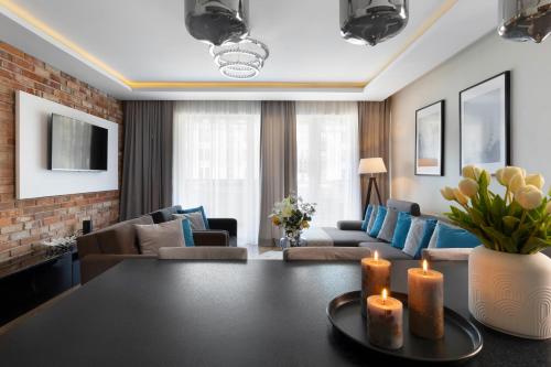sala de estar con mesa y 2 velas en Elite Apartments Downtown Premium en Gdansk