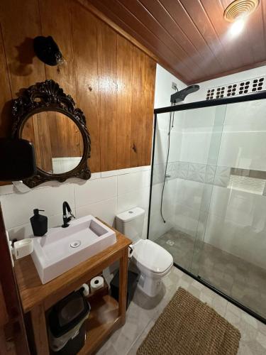 a bathroom with a sink and a toilet and a mirror at Recanto do Cisne in Biguaçu