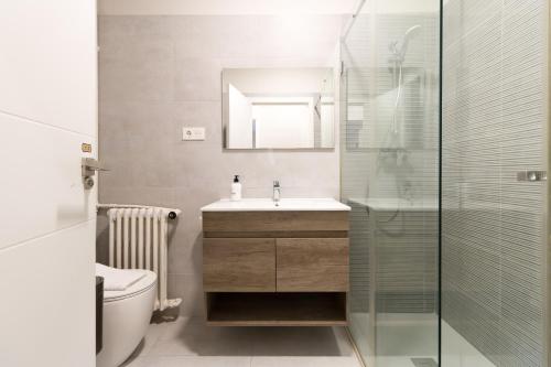 ein Bad mit einem Waschbecken und einer Glasdusche in der Unterkunft BILBAO ARGIA in Bilbao