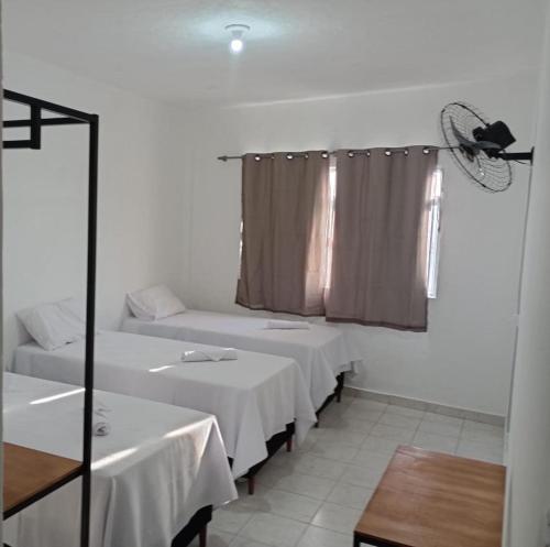 Habitación con 2 camas y ventana con ventilador. en Angelus Hotel & Estacionamento en Campos dos Goytacazes