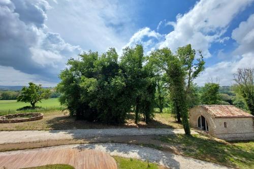 a tree and a building in a field at Agriturismo Biancarda in Massignano