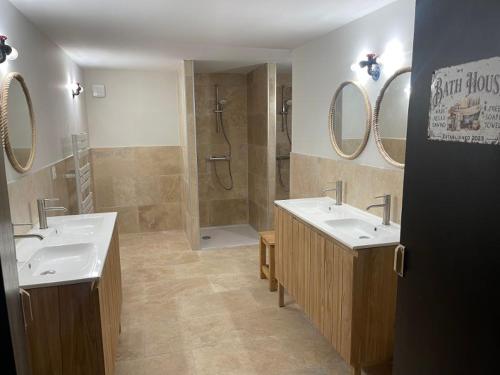 ein Badezimmer mit zwei Waschbecken, einer Dusche und zwei Spiegeln in der Unterkunft Villa du Parc le Sapin in Formiguères