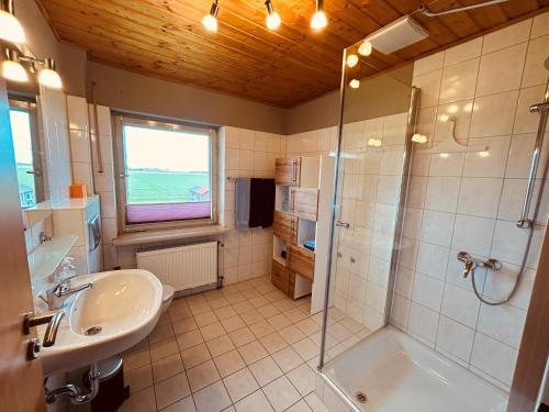 a bathroom with a shower and a sink at Pension zum Krug, Messe München in Hergolding