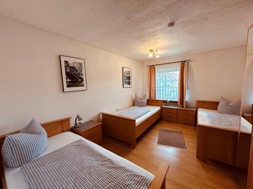 a room with two beds and a window at Pension zum Krug, Messe München in Hergolding