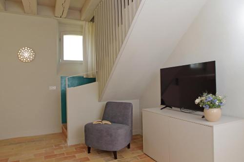 a living room with a tv and a chair at Agriturismo Biancarda in Massignano