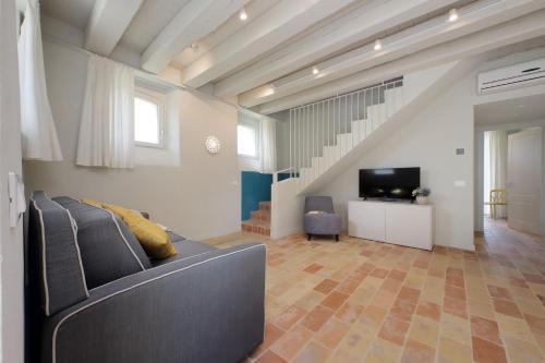 a living room with a couch and a television at Agriturismo Biancarda in Massignano