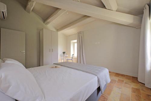 a bedroom with a white bed and a window at Agriturismo Biancarda in Massignano