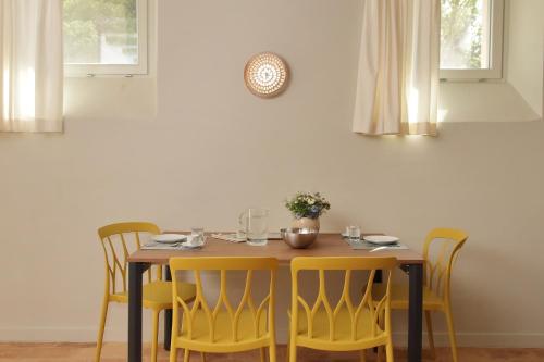 a dining room table with yellow chairs around it at Agriturismo Biancarda in Massignano
