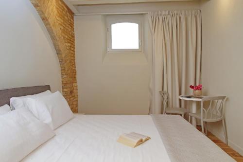a bedroom with a white bed with a book on it at Agriturismo Biancarda in Massignano