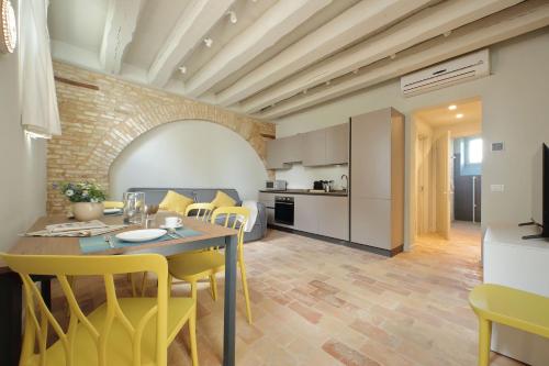 a kitchen and dining room with a table and yellow chairs at Agriturismo Biancarda in Massignano