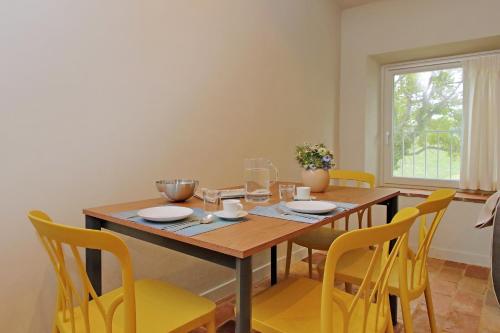 a dining room with a wooden table and yellow chairs at Agriturismo Biancarda in Massignano