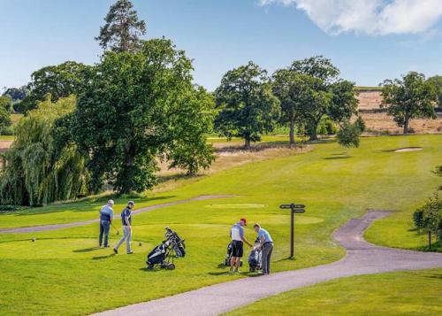 un grupo de personas jugando al golf en un campo de golf en The Astbury Golf And Lodge Resort, en Bridgnorth