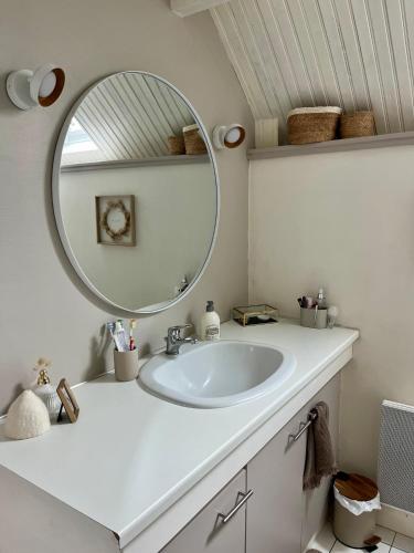 une salle de bain avec un lavabo blanc et un miroir dans l'établissement Maison de pêcheur - Golfe du Morbihan, à Saint-Gildas-de-Rhuys