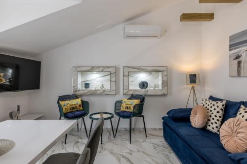 Una sala de estar con un sofá azul y dos sillas. en Royal Blue Marine, en Vodice