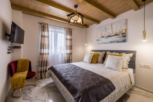 Un dormitorio con una cama grande y un televisor. en Royal Blue Marine, en Vodice