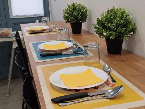 a table with plates and utensils on top of it at Giardino Siciliano B&B in Catania
