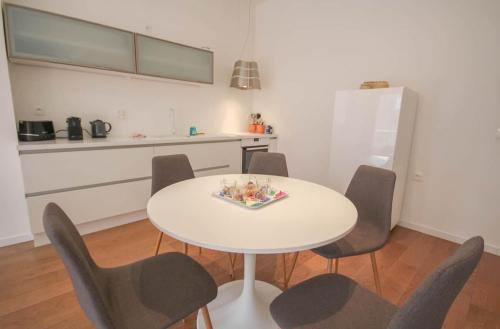 une table blanche et des chaises dans une cuisine dans l'établissement Appartement cosy en hypercentre de Lille, à Lille