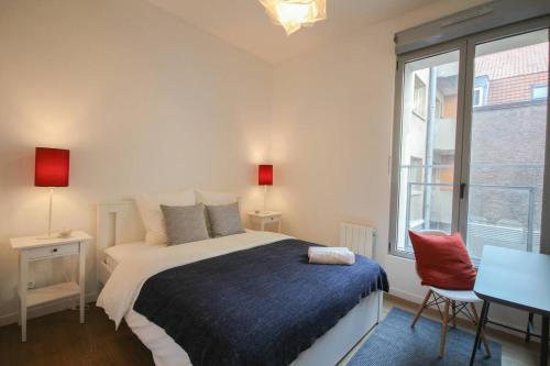 une chambre avec un lit et une grande fenêtre dans l'établissement Appartement cosy en hypercentre de Lille, à Lille