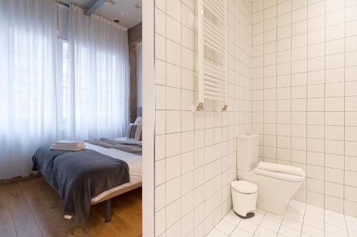 a bathroom with a bed and a toilet in a room at NEW! San Mames in Bilbao