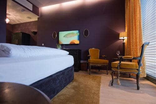 um quarto de hotel com uma cama, uma mesa e cadeiras em Hotel Lava Inn - 24 h Check-In - Nähe LKH, Landeskrankenhaus, Feldbach em Feldbach