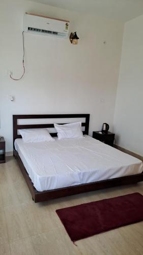 a bedroom with a large bed with a white bedspread at The Agroon Inn in Haldwāni