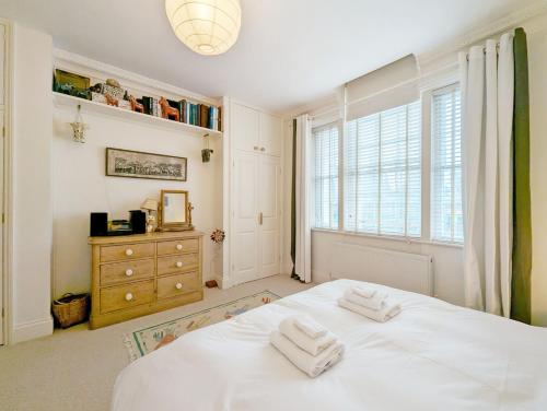 1 dormitorio con cama blanca y ventana en 4 The Clockhouse , Midhurst, en Midhurst