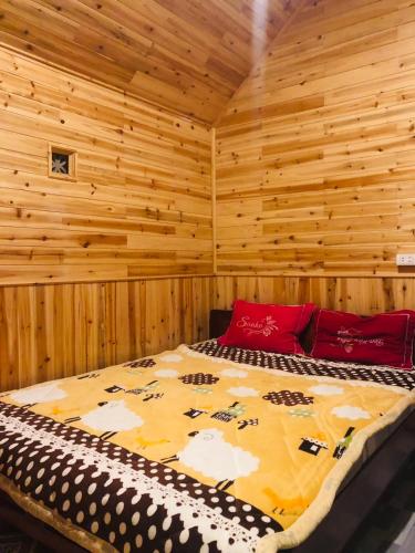 a bedroom with a bed in a wooden room at MAMA LILI'S HOMESTAY in Hao Su Ngai