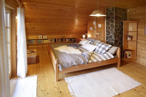 ein Schlafzimmer mit einem Bett in einem Blockhaus in der Unterkunft Charming Chalet Rogla in Hudinja