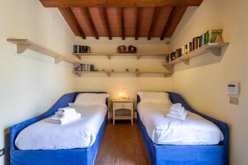 two beds in a small room with a table at Fienile I Cipressi - Retreat with stunning views in Impruneta