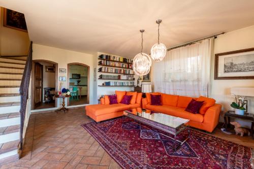 a living room with orange couches and a rug at Fienile I Cipressi - Retreat with stunning views in Impruneta