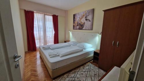 Habitación pequeña con cama y ventana en Adeona Apartments, en Ohrid