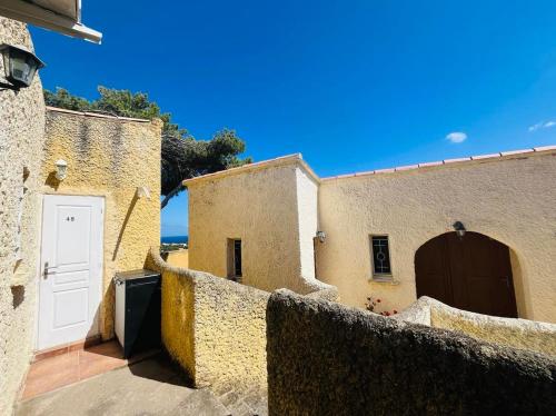 a building with a white door and a fence at Studio Cocody 49 LUMIO in Lumio