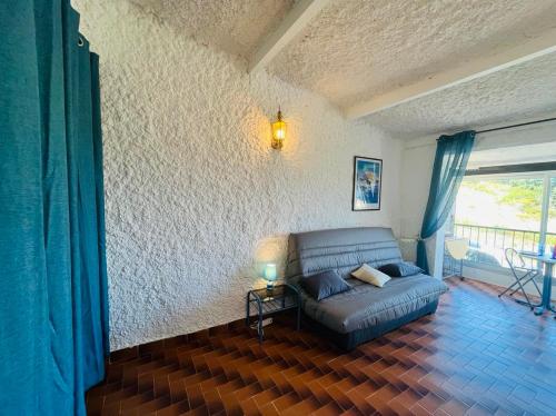 a living room with a couch in a room at Studio Cocody 49 LUMIO in Lumio