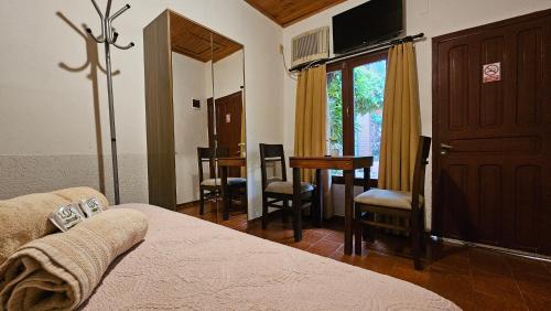 a bedroom with a bed and a table and chairs at Iguazu Hojas Verdes in Puerto Iguazú