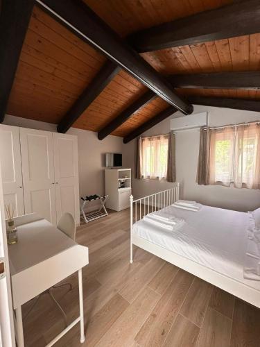 a bedroom with a large white bed and wooden ceilings at Dimora Santa Rosalia in Alba