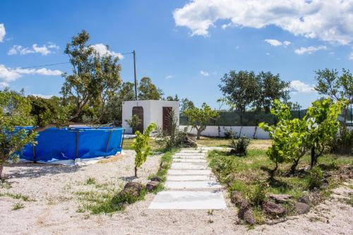 um jardim com um caminho que conduz a um edifício em Villa Tonzi Country House em Orosei