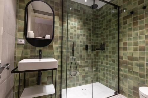 a bathroom with a shower with a sink and a mirror at DuoMo Hotel in Rimini