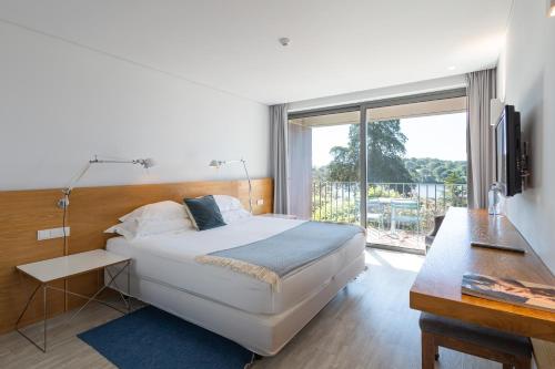 a bedroom with a bed and a large window at Vale do Gaio Hotel in Torrão