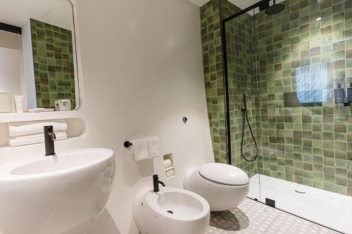 a bathroom with a sink and a toilet and a shower at DuoMo Hotel in Rimini