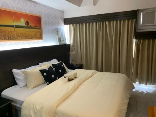 a bedroom with a large bed with white sheets and pillows at Marvee’s Haven Tagaytay Staycation in Tagaytay