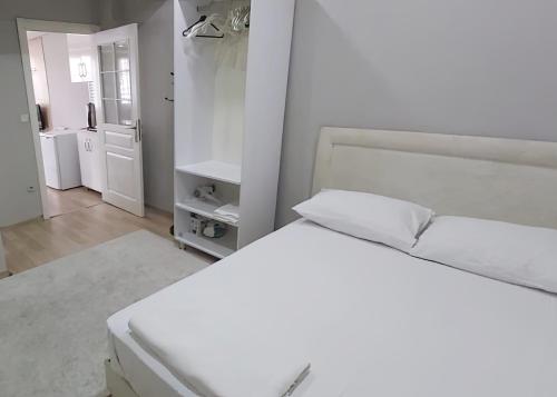 a white bedroom with two beds and a bathroom at Hane Apart in Istanbul