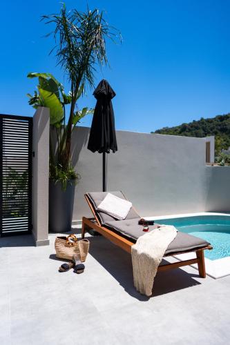 a patio with a bed and a swimming pool at Afesou Suites in Ialyssos