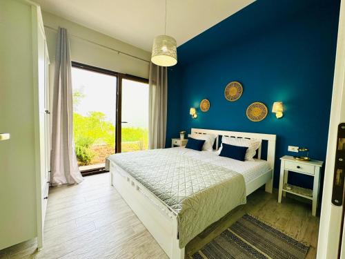 Dormitorio azul con cama y pared azul en Boka horizont en Kotor